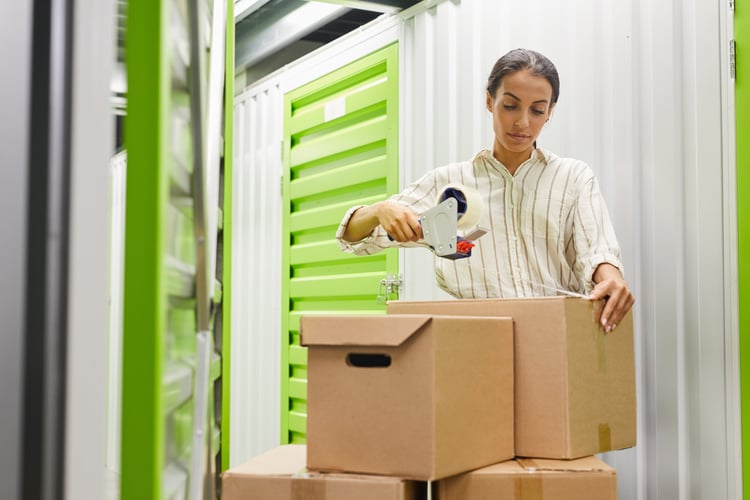 woman taping boxes at a self storage facility