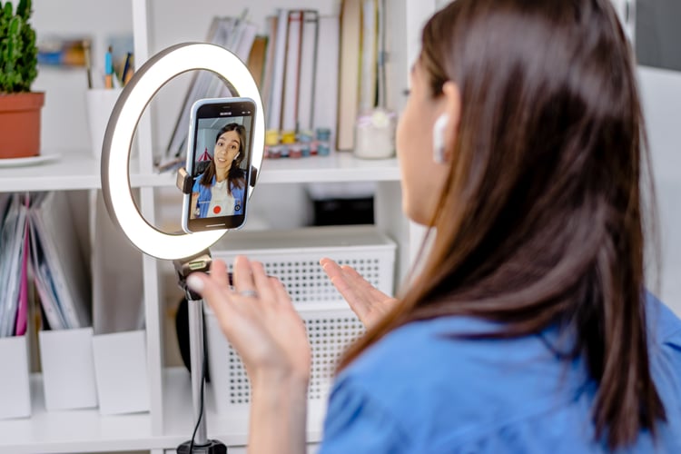 influencer with a ringlight filming a live video