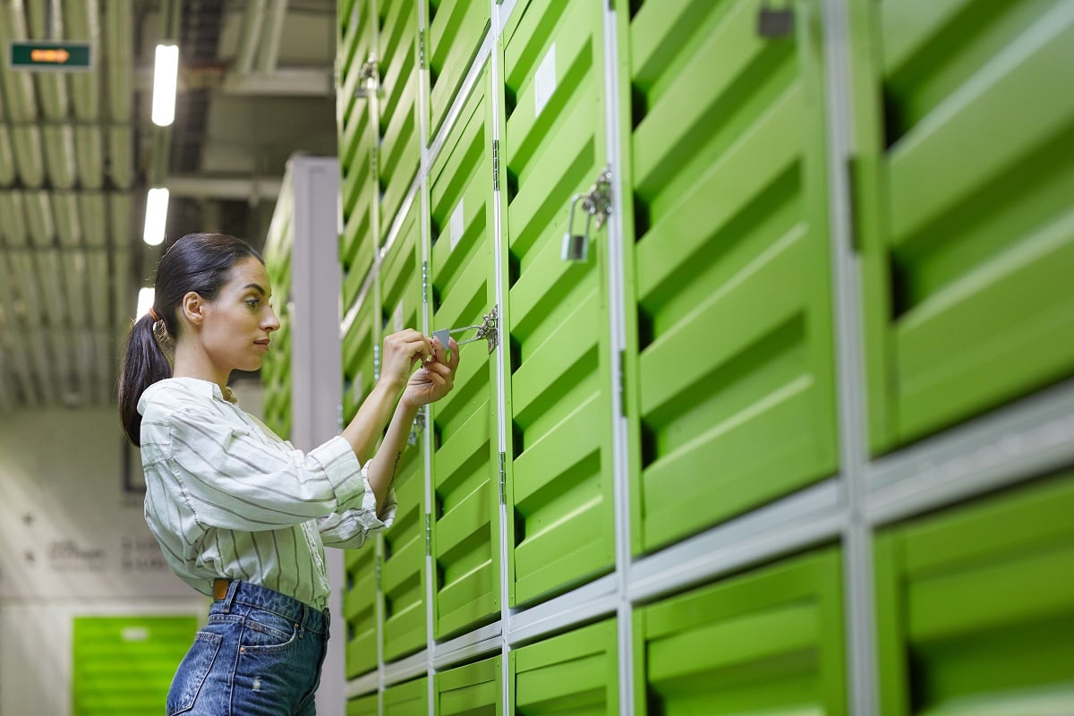woman using self storage security solutions in green storage units